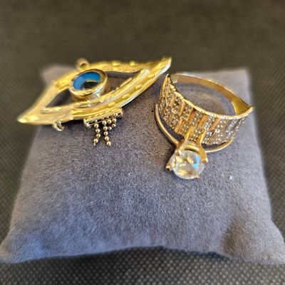 deux bagues et une bague posée sur un coussin posé sur une table