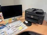 a computer on a desk with a printer and a mouse