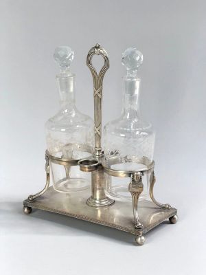 two glass decanters on a metal stand with a silver base