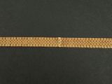 a close up of a gold bracelet on a black surface