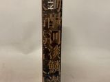 an old book with chinese writing on it sitting on a white surface