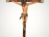 a statue of jesus on the cross with a hat on his head