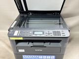 a printer sitting on top of a white sheet next to a printer
