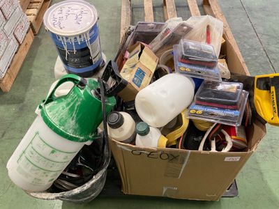 une boîte en carton remplie d'articles divers, posée sur une palette