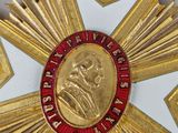 a close up of a gold medal with a red center