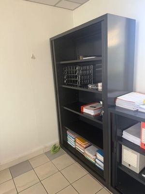 a black bookcase with many books on it in a room