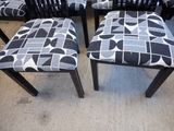 four black and white chairs with black and white patterned upholstered seats