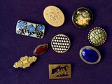 many different types of brooches and brooches on a purple surface