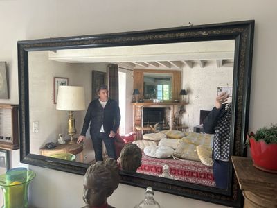 deux personnes debout devant un miroir dans un salon