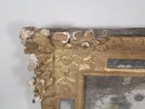 a mirror with a gold frame and a white wall behind it
