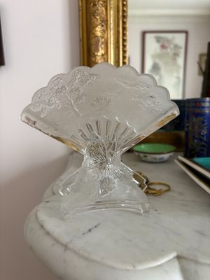 un vase en verre posé sur une table en marbre, avec un miroir en arrière-plan