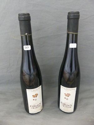 two bottles of wine are sitting on a table with a gray background
