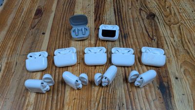 a lot of white airpods sitting on a wooden table
