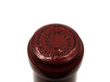 a close up of a bottle of wine on a white surface