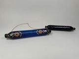 un stylo bleu orné d'un motif floral, à côté d'un stylo noir
