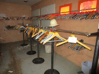 beaucoup de vêtements suspendus à une étagère dans une pièce