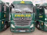 three green trucks parked next to each other in a parking lot