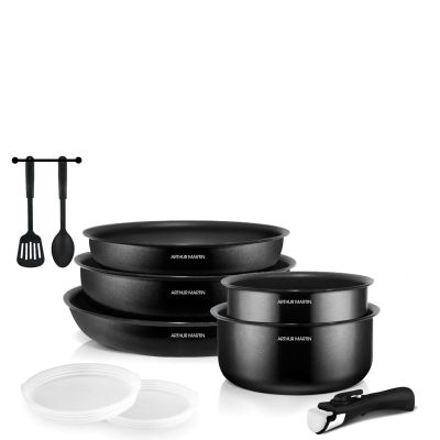 trois casseroles noires et une cuillère posées sur un plan de travail blanc