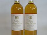 two bottles of wine sitting next to each other on a white surface