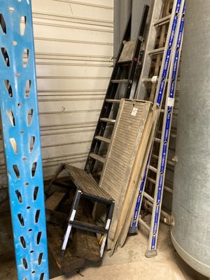 a stack of ladders next to a water heater in a garage