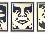 three black and white paintings of faces on a white wall