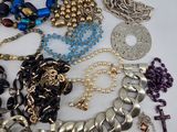 many different types of necklaces and bracelets laid out on a table
