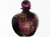 une bouteille en verre violette ornée d'un motif floral