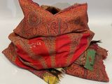 a pile of red and orange blankets on a table