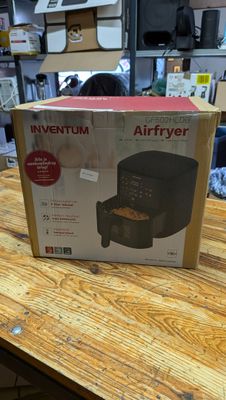 an open box of an air fryer sitting on a wooden table