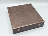 an old book with a brown cover sitting on top of a white table