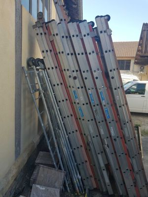 a pile of skis leaning against the side of a building