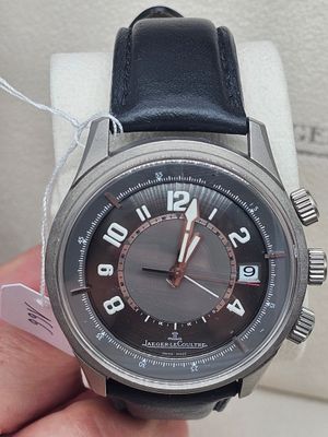 une personne tenant une montre à la main, sur laquelle est accrochée une étiquette de prix