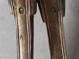 pair of antique silver plated spoons with handles on a table