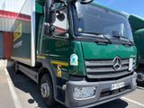 un camion vert garé sur un parking