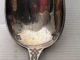 a silver spoon with a red handle sitting on a table