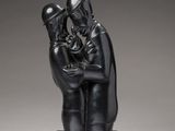 a black sculpture of a man and a woman sitting on a bench