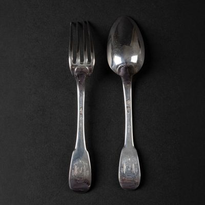 two spoons and a fork on a black surface