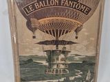 an old book with a picture of a hot air balloon flying over the ocean
