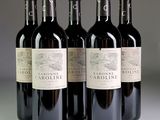 quatre bouteilles de vin rouge sont alignées