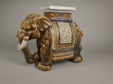 un éléphant en céramique avec un siège sur le dos