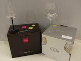 two wine glasses sitting next to a box on the floor