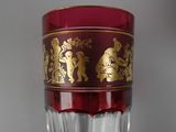 a red glass with a gold design on it