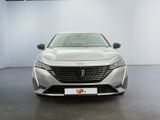 the front view of a silver car parked in a showroom