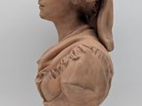 a close up of a clay bust of a woman wearing a hat