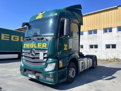 un camion vert garé devant un immeuble