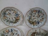 three plates with floral designs on them sitting on a table