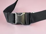 a black belt with a metal buckle on a pink background
