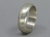 a close up of a silver ring on a gray surface