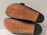 pair of black leather shoes with black soles on a white surface