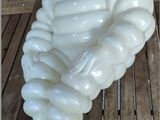 a white inflatable statue of a man sitting on a table